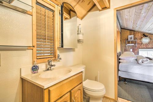 Un baño con lavabo, inodoro y una cama. en Serene Seldovia Cabin, en Seldovia