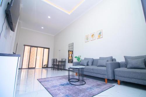 a living room with a couch and a table at Villa Azzalea Private Pool dan Rooftop in Batu