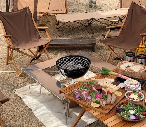 久住にあるくじゅう花公園　キャンピングリゾート花と星の食べ物をテーブルに並べたグリル