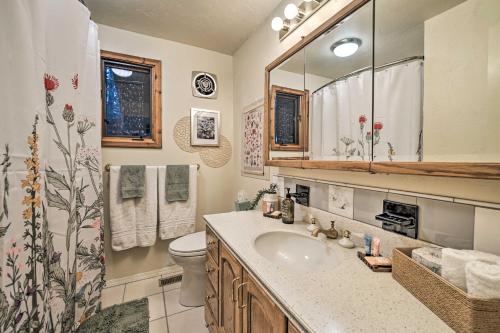 ein Badezimmer mit einem Waschbecken, einem WC und einem Spiegel in der Unterkunft Swanhouse. Waterfront home. in Seldovia