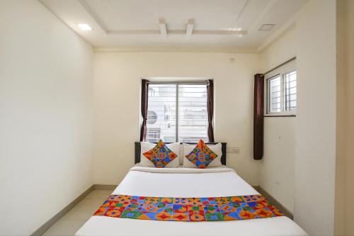 a bedroom with a bed with a colorful blanket on it at FabHotel HRG Destiny in Nagpur