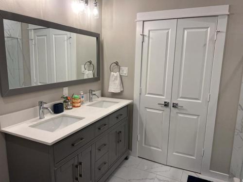 baño con 2 lavabos y espejo grande en Charming House Downtown en Houston