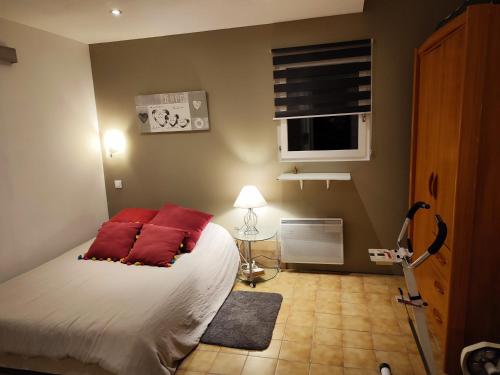 - une chambre avec un lit doté d'oreillers rouges dans l'établissement Maison proche de la mer et de Pézenas, à Tourbes