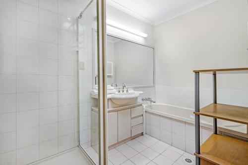 a white bathroom with a sink and a shower at 3BR Peaceful and Quiet Elanora Sanctuary in Gold Coast