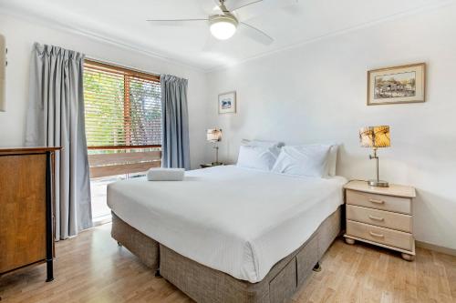 a bedroom with a large bed and a window at 3BR Peaceful and Quiet Elanora Sanctuary in Gold Coast