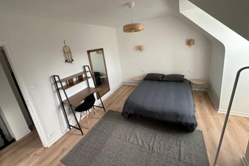 1 dormitorio con cama y espejo en la pared en Maison 3 chambres à 5 min de la mer, en Tregueux