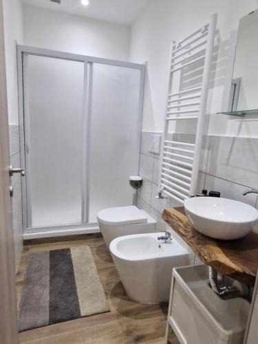 a white bathroom with a sink and a toilet at SAINT GEORGE'S HOUSE Bari in Bari
