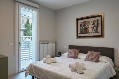 Un dormitorio con una cama grande con almohadas. en MALVEZZi Apartments, en Desenzano del Garda
