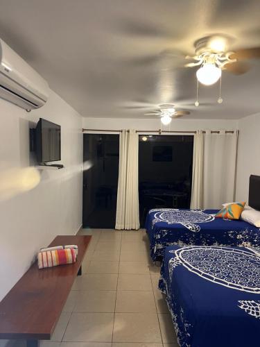 a hotel room with two beds and a table at Aloha Lobitos in Lobitos