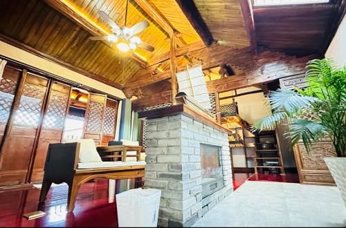 a living room with a fireplace and a wooden ceiling at Qingxin Courtyard Art Guesthouse in Dali