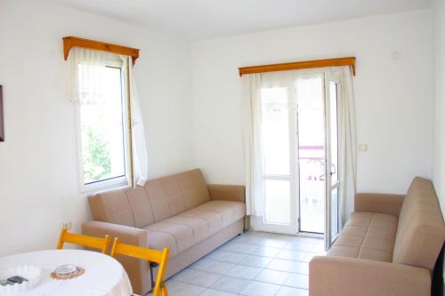 a living room with two couches and a table at Toloman Bitezpark Apartments in Bodrum City