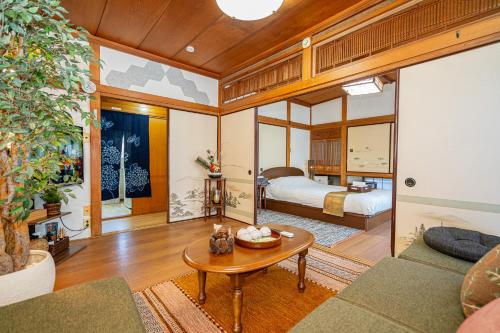 a living room with a bed and a table at Jujo house Direct to Shinjuku in Tokyo