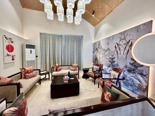 a living room with couches and chairs and a painting at Ananta Spa & Resort Jaipur in Jaipur