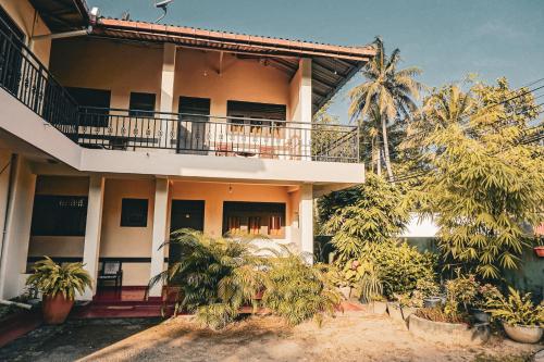 un edificio con balcone e palme di Sunny Lanka Guest House a Matara