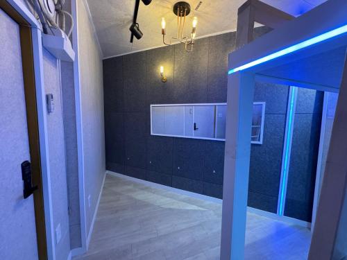 Habitación con paredes negras y luz azul en IMC studio, en Seúl