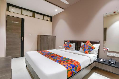 ein Schlafzimmer mit einem großen Bett in einem Zimmer in der Unterkunft FabExpress Ospite in Surat