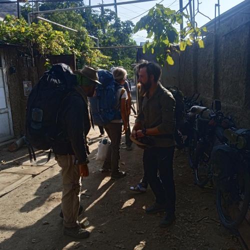 a group of men with backpacks standing in a alley at Мргануш in Meghri