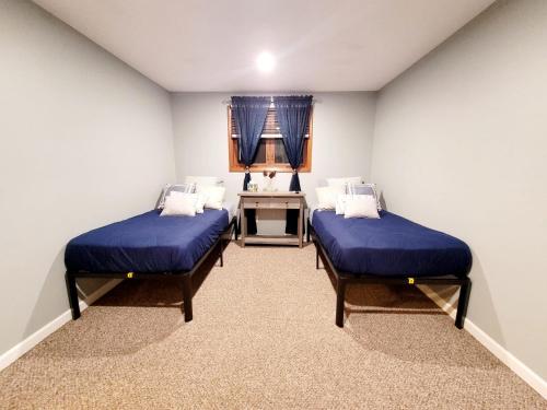a room with two beds and a desk in it at Spacious Buffalo Niagara Falls Apt, Close to Buffalo Airport in Depew