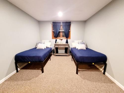 Spacious Buffalo Niagara Falls Apt, Close to Buffalo Airport في Depew: غرفة بسريرين ومكتب فيها