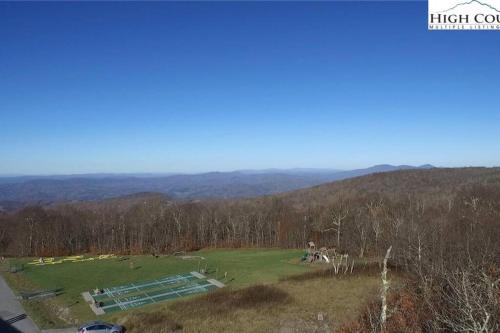 an aerial view of a large green field with trees at On Top Of Everything at Beech in Beech Mountain
