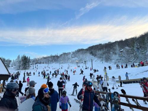 a group of people on a ski slope in the snow at On Top Of Everything at Beech in Beech Mountain