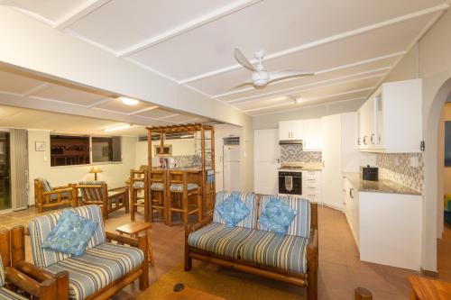 ein Wohnzimmer mit Sofas und eine Küche in der Unterkunft Fleurpark 71 in Gordonʼs Bay
