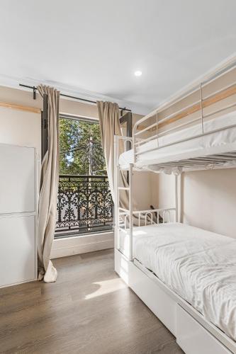 a bedroom with two bunk beds and a window at Azzurro Boutique Hotel - Surry Hills in Sydney
