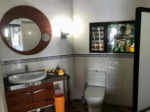 a bathroom with a sink and a toilet and a mirror at Camotes Cay Hideaway in San Francisco
