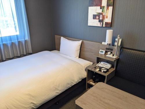 Postel nebo postele na pokoji v ubytování Hotel Route-Inn Chiba Hamano -Tokyowangando-
