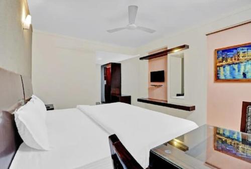 Dieses weiße Zimmer verfügt über ein Bett und einen Schreibtisch. in der Unterkunft AEC Travel and Leisure Solution Pvt Ltd in Alappuzha