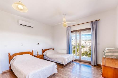 um quarto com 2 camas e uma janela em Mountain/sea view 6 Bedroom Villa in Chirokitia em Lárnaca
