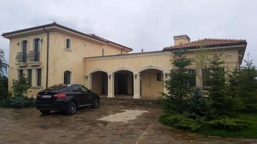 une voiture noire garée devant une maison dans l'établissement Vila in stil mediterranean, à Crevedia