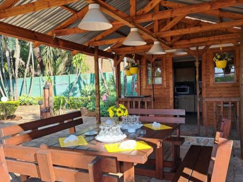 un patio de madera con mesa y sillas en La Frans Guesthouse en Pretoria