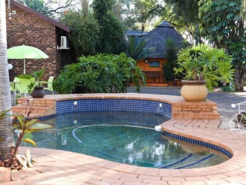 a swimming pool in a yard with a patio at La Frans Guesthouse in Pretoria