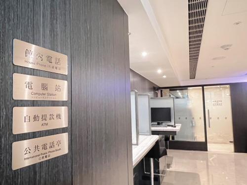 a room with signs on a wall with a desk at Taichung Harbor Hotel in Wuqi