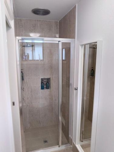 a shower with a glass door in a bathroom at Blue Lago at Raffertys Resort in Cams Wharf