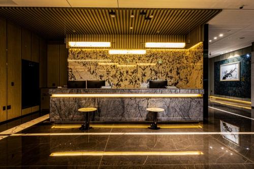 eine Lobby mit einer Bar mit Hockern in der Unterkunft Jeju Bolton Hotel in Jeju-do