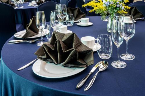 a table with a blue table cloth and a plate with napkin at Jeju Bolton Hotel in Jeju