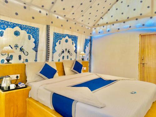 a bedroom with a large bed with blue and white decorations at Golden Fort Resort in Jaisalmer