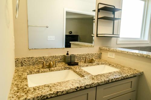 a bathroom with two sinks and a mirror at Come enjoy this modern, luxury oasis! 15 mins from downtown and the airport in Atlanta