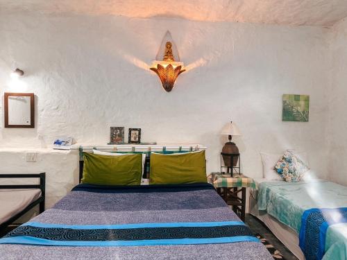 a bedroom with two beds and a light fixture at Baan Suanthip Homestay - Aoluek Natural Retreat in Ao Luk