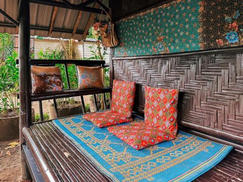 a bench with colorful pillows sitting on it at Baan Suanthip Homestay - Aoluek Natural Retreat in Ao Luk
