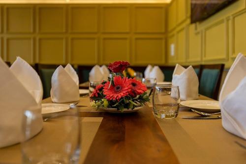 a table with a vase of red flowers on it at Mertiya Residency in Jodhpur
