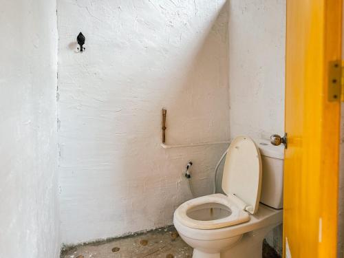 a bathroom with a toilet and a black cat on the wall at Baan Suanthip Homestay - Aoluek Natural Retreat in Ao Luk