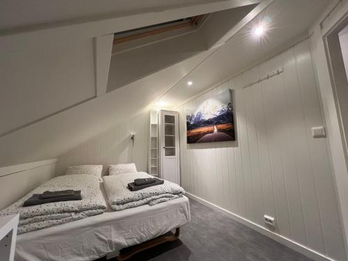 a bedroom with two beds and a picture on the wall at Oggevatn in Birkenes