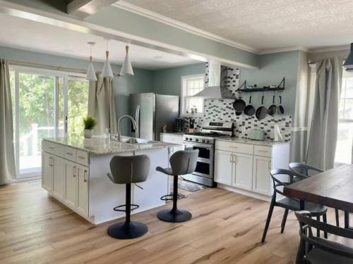 a kitchen with white cabinets and a table and chairs at Waterfront house near the Niagara Falls/Canal/Canadian Border in Tonawanda