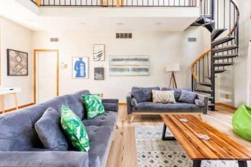 a living room with blue couches and a wooden table at Waterfront house near the Niagara Falls/Canal/Canadian Border in Tonawanda