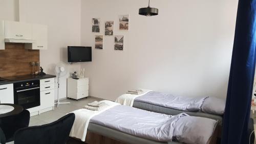 a small room with two beds and a kitchen at Komfortowy apartament w centrum Nowego Sącza in Nowy Sącz