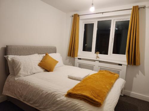 Un dormitorio con una cama con una manta amarilla. en Full House on Crab Lane en Hednesford