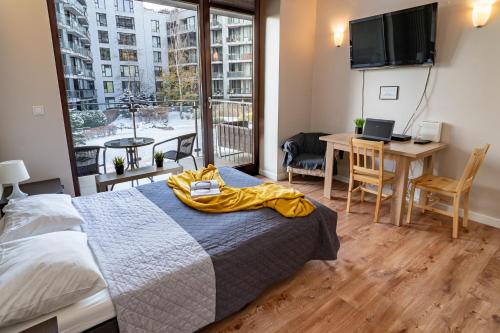 Un dormitorio con una cama con una manta amarilla. en Apartamenty Triton Park, en Varsovia